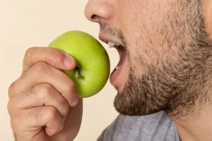man biting into an apple